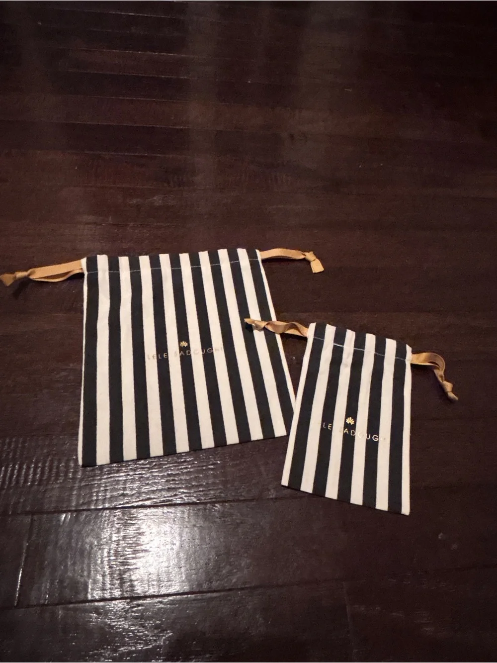 Lele Sadoughi Black and White Striped Drawstring Pouches with Gold Logo